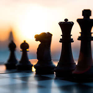 Game of chess and sunset in the background