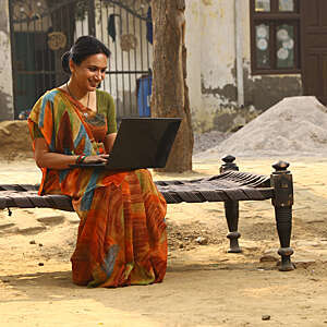 Indian Happy rural women working on laptop in village. 