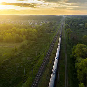 Freight train on the railroad at sunrise. Aerial view